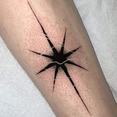 a black and white photo of a star tattoo on the right leg, with dots all over it