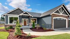 a gray house with two car garages on the front and one door is open