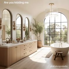 a large bathroom with two sinks and a bathtub in the middle, surrounded by arched windows