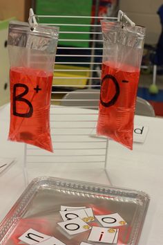 two bags filled with red liquid sitting next to each other on top of a table