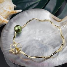 This Bangle Bracelet Features A Beautiful Shell On Tarnish Resistant Gold Hammered Wire. Green Shell And Hibiscus Charm. Very Comfortable And Light Weight While Sturdy Enough To Hold Its Shape. The Band Is Approximately 2mm In Width. The Hammered Design Gives This Bracelet A Beautiful Lusturous Shine. Pearls Are Approximately 9-10 Mm In Size. This Is Gold Plated Jewelry, Not Gold Filled Or Solid Gold. Bracelet Measurements: Size 6.5 - Toddler Size 7 - Childrens Size Size 7.5 - Small Womens Size Hawaiian Shell Jewelry, Hawaii Bangles, Hawaiian Bangles, Gold Green Necklace, Bracelet Measurements, Hawaii Aesthetic, Custom Charm Bracelet, Kate Spade Bangle, Solid Gold Bracelet