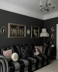 a living room filled with black and white furniture next to a painting on the wall