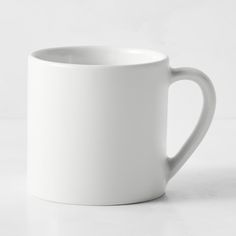 a white coffee cup sitting on top of a table