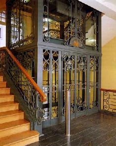 the stairs are made of wood and wrought iron, with glass doors on each side