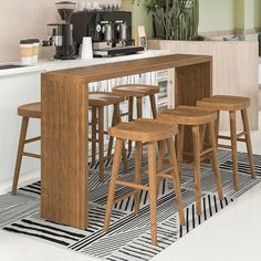 a kitchen island with stools in front of it and coffee maker on the counter