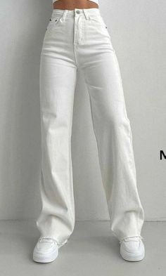 a woman in white pants and heels posing for the camera with her hands on her hips