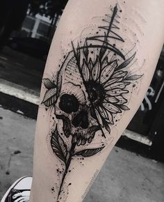 a skull and sunflower tattoo on the leg