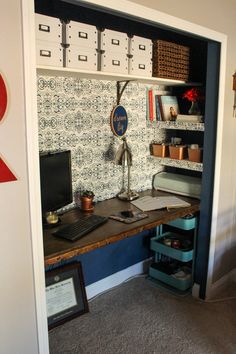 a desk with a laptop computer on top of it next to a wall mounted shelf