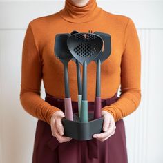 a woman is holding some utensils in her hands