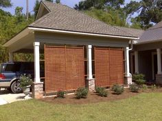 a car is parked in front of a house with wooden screens on the side of it