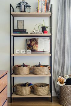 a book shelf with baskets and books on it