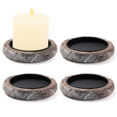 three candles are sitting next to each other in front of a candle holder with an owl design on it