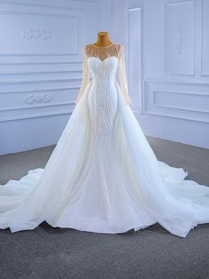 a white wedding dress on display in a room