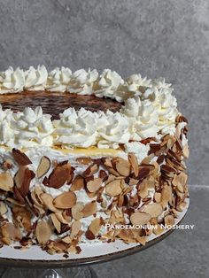 a cake with white frosting and nuts on top