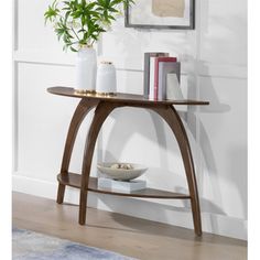 a wooden table with two shelves and a vase on it next to a wall mounted plant