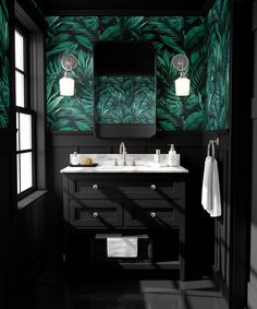 a black and white bathroom with green leaves on the wall, two sinks and mirrors