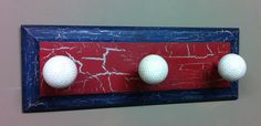 three golf balls mounted to a red and blue wall