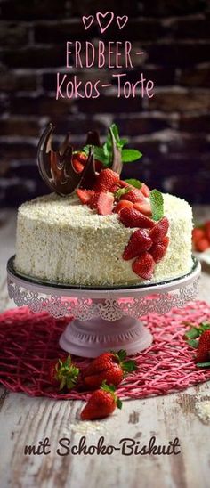 a white cake with strawberries on top and the words erdbeer - kolos - torte above it