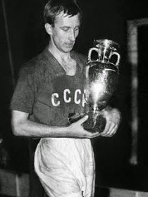 a black and white photo of a man holding a trophy