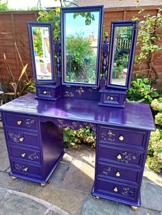 a purple desk with two mirrors on it