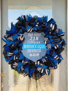 a blue wreath with black and white ribbons on it