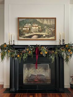 a fireplace decorated for christmas with greenery and candles