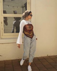 a woman in white shirt and jeans with a backpack on her back walking by a window