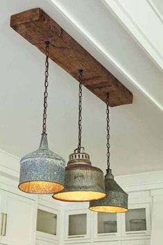 three light fixtures hanging from the ceiling in a kitchen