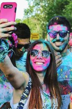 a group of people standing next to each other with colored paint on their faces and body