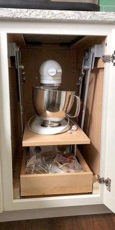 an open cabinet with a mixer in it