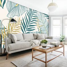 a living room with a couch, coffee table and large wall mural in the background