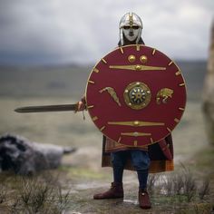 a man dressed as a roman soldier holding a shield