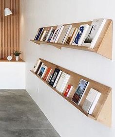 two wooden bookshelves on the side of a wall