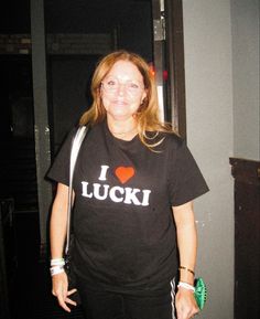 a woman wearing a t - shirt that says i love luck with a heart on it