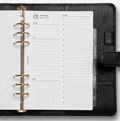 a black leather planner book with gold trim and numbers on the front cover is open