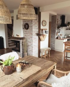 a living room filled with furniture and a fire place next to a brick wall on top of a hard wood floor