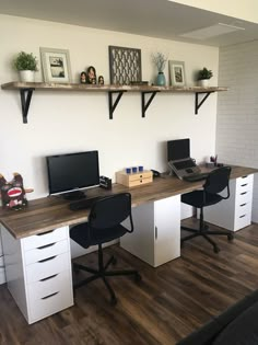 an office with two desks and three computer monitors