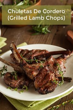 grilled lamb chops on a white plate with herbs in the background and text overlay that reads chiletas de cordero grilled lamb chops