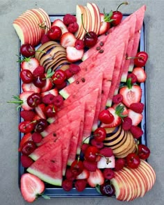 watermelon slices, strawberries and cherries arranged on a platter for a fruit tray