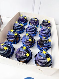 cupcakes with blue frosting and stars in a box