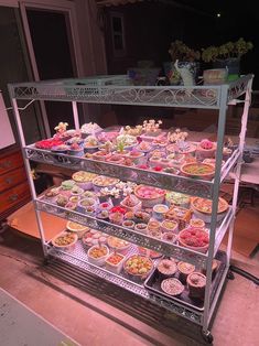 a display case filled with lots of different types of desserts on top of metal shelves