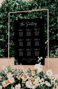 the seating sign was set up with flowers and greenery