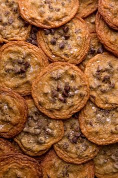 chocolate chip cookies are piled on top of each other in this close up photo taken from above