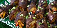 a plate full of food with toothpicks in it on a green tablecloth