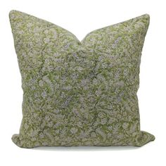 a green and white pillow on a white background