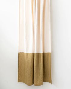 a white and gold curtain hanging on a wall