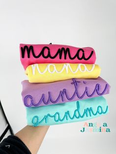 a person holding three pillows with the words mama, mamo, qunive and grandma written on them