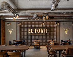 an empty restaurant with tables and chairs in front of the wall that reads el torr