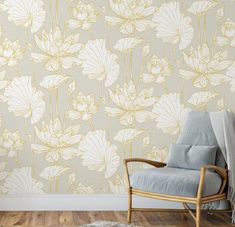 a chair sitting in front of a wall with white flowers painted on the wall behind it