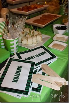 a green table topped with lots of food and desserts on top of it's tables